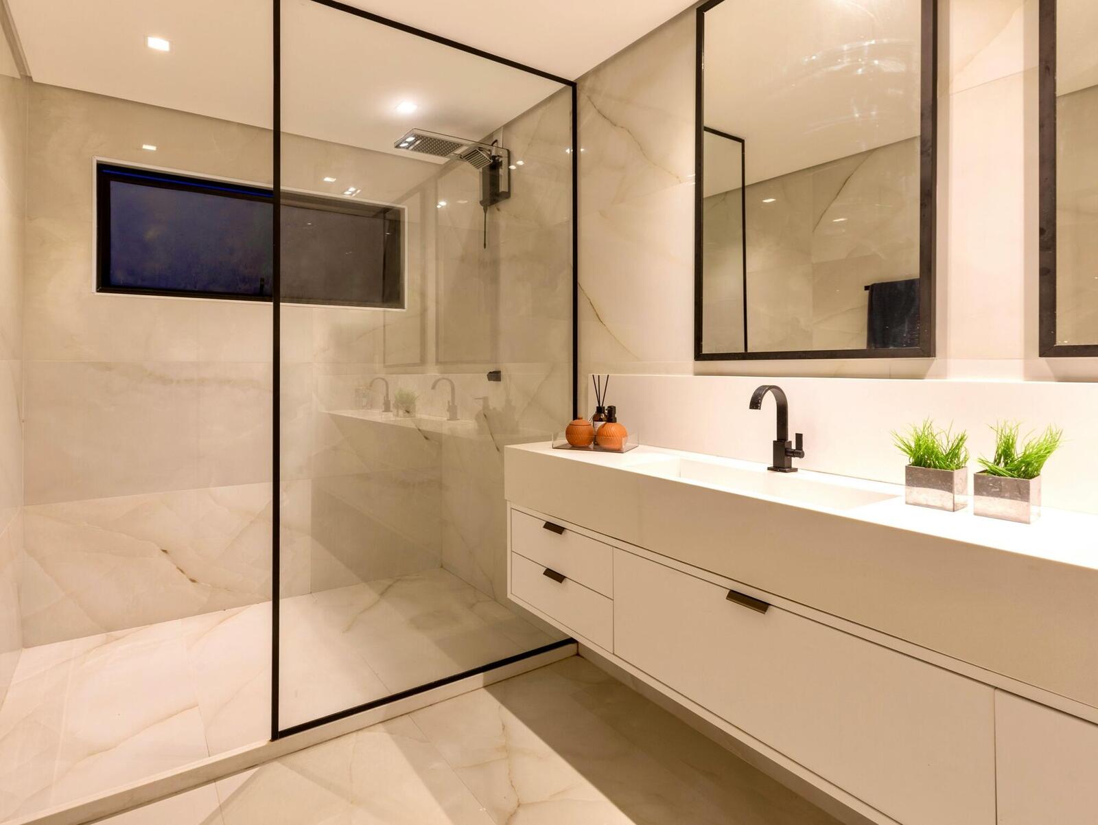 WC premium com mármore ónix, box duche perfil preto minimal e lavatório de bancada